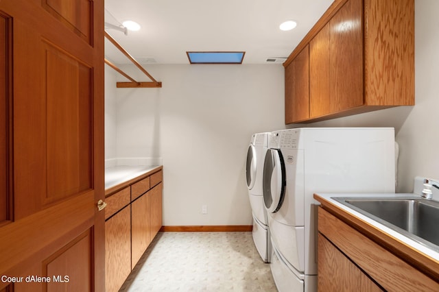 clothes washing area with cabinet space, visible vents, baseboards, independent washer and dryer, and a sink