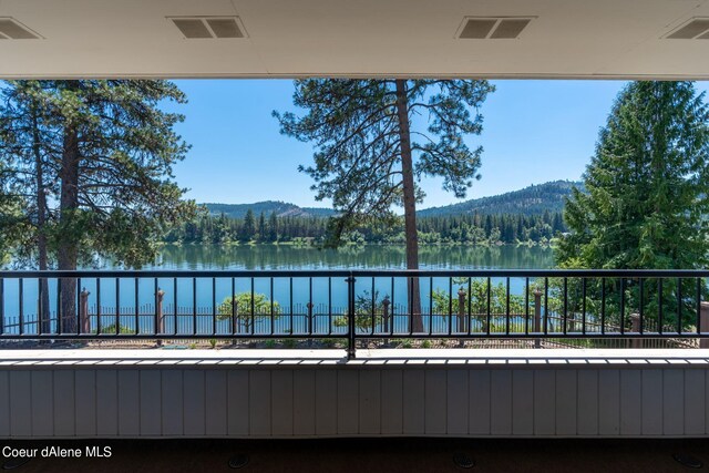 balcony featuring a water and mountain view and visible vents