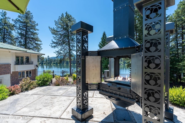 exterior space featuring a water view and an outdoor fire pit