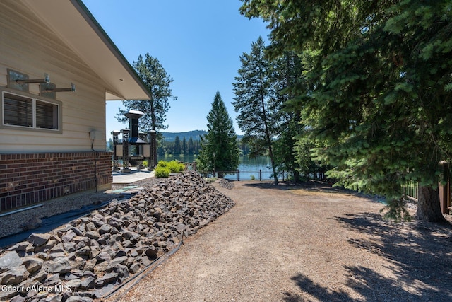 view of yard with a water view and fence