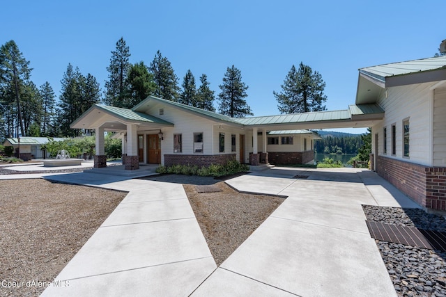 exterior space featuring metal roof, brick siding, and a standing seam roof