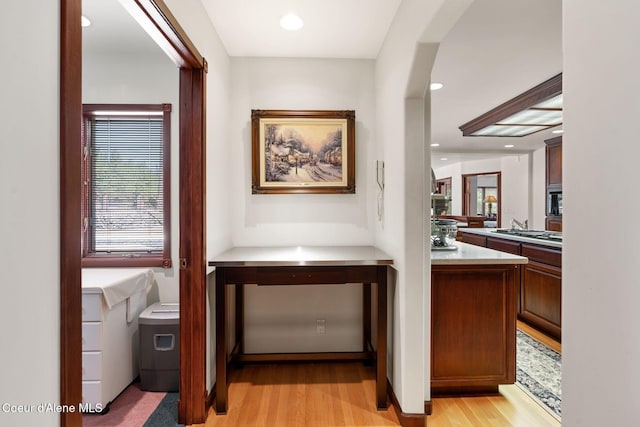 bar with arched walkways, recessed lighting, stainless steel gas stovetop, and light wood-style floors