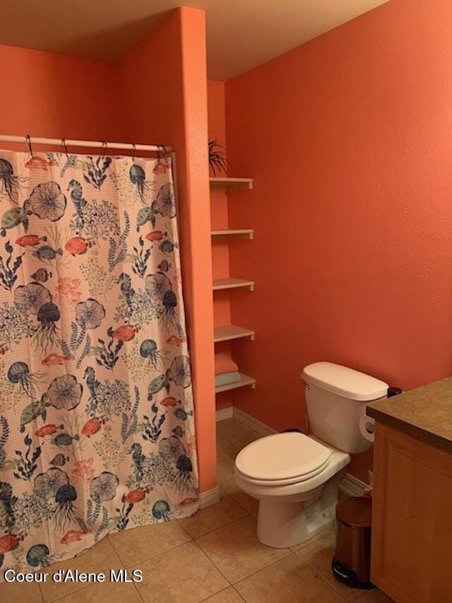 full bath featuring a shower with shower curtain, toilet, vanity, tile patterned flooring, and baseboards