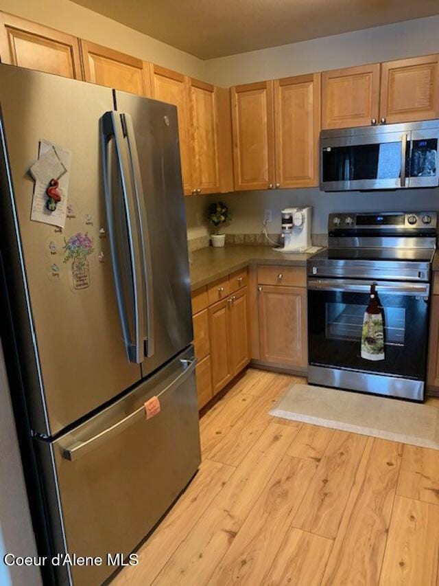 kitchen with appliances with stainless steel finishes and light wood-style flooring