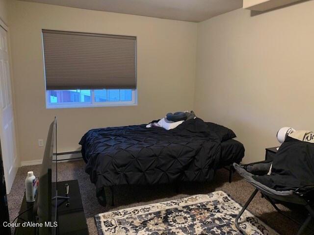 carpeted bedroom featuring a baseboard radiator