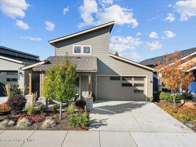 view of front of property featuring a garage, driveway, and a shingled roof