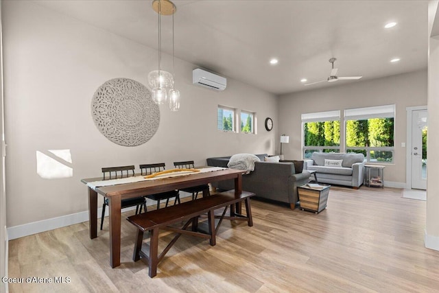 dining room featuring light wood-style flooring, recessed lighting, ceiling fan with notable chandelier, baseboards, and an AC wall unit