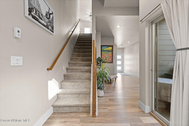 staircase featuring recessed lighting, wood finished floors, and baseboards