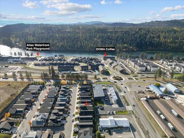 birds eye view of property featuring a water view and a view of trees