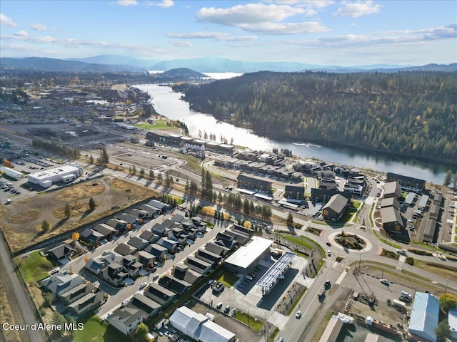 birds eye view of property with a wooded view and a water and mountain view