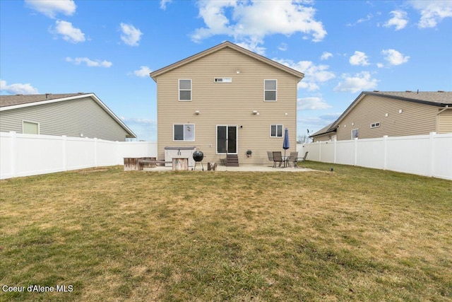 rear view of house featuring a patio, a yard, and a fenced backyard