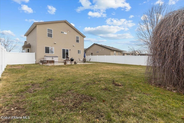 rear view of house with a yard, a patio, and a fenced backyard