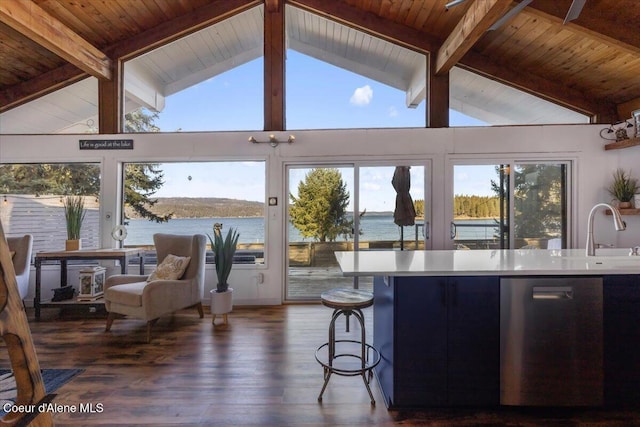 kitchen with vaulted ceiling with beams, a water view, a sink, dark wood-style floors, and dishwasher