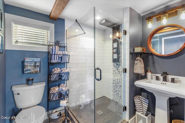 bathroom with toilet, a stall shower, and beamed ceiling