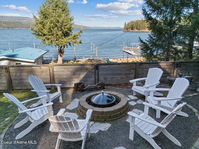 view of patio featuring an outdoor fire pit, a fenced backyard, and a water view