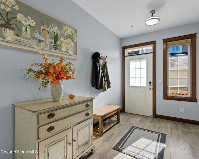 foyer entrance featuring baseboards and light wood-style floors