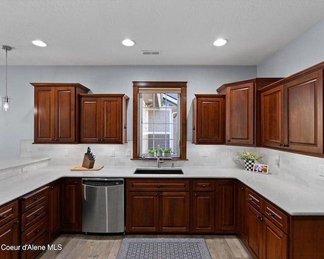 kitchen with dishwasher, backsplash, a sink, and visible vents