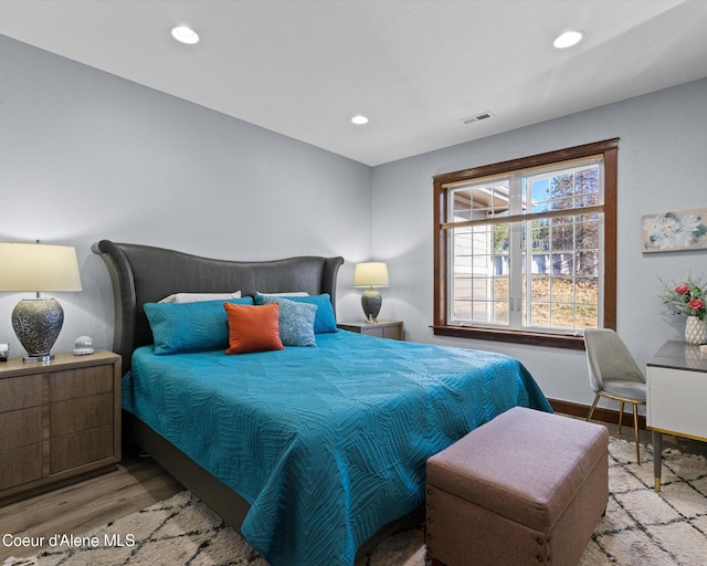 bedroom with recessed lighting, visible vents, baseboards, and wood finished floors