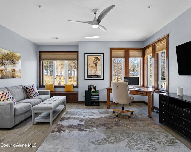 home office with a ceiling fan, visible vents, a wealth of natural light, and wood finished floors