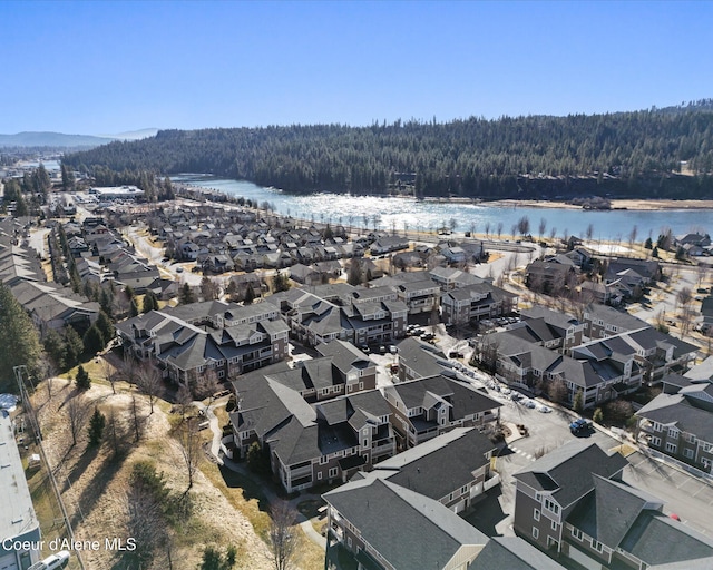 drone / aerial view featuring a water view, a residential view, and a view of trees