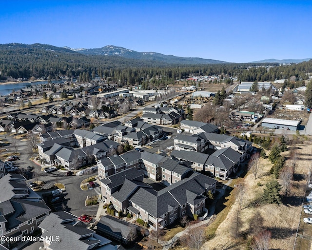 drone / aerial view featuring a residential view, a mountain view, and a view of trees