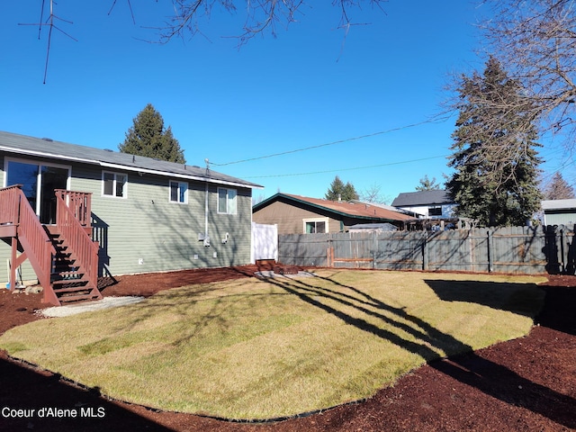 view of yard with stairs and a fenced backyard