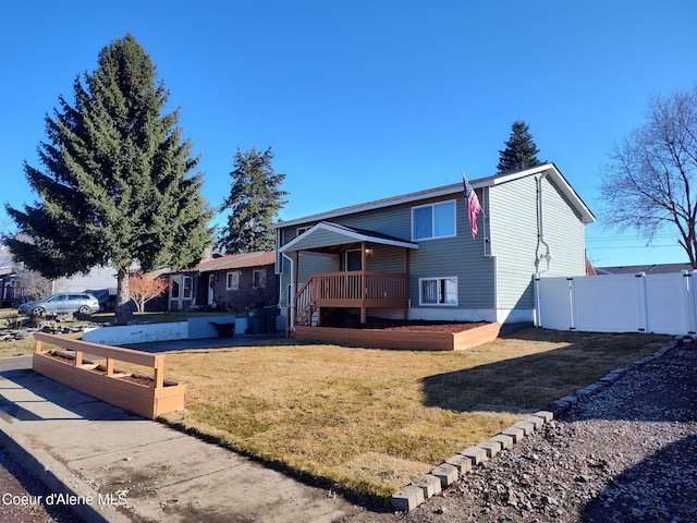 view of front of house with a gate, fence, and a front lawn