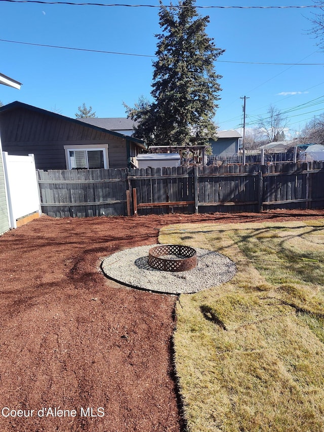 view of yard featuring an outdoor fire pit and fence