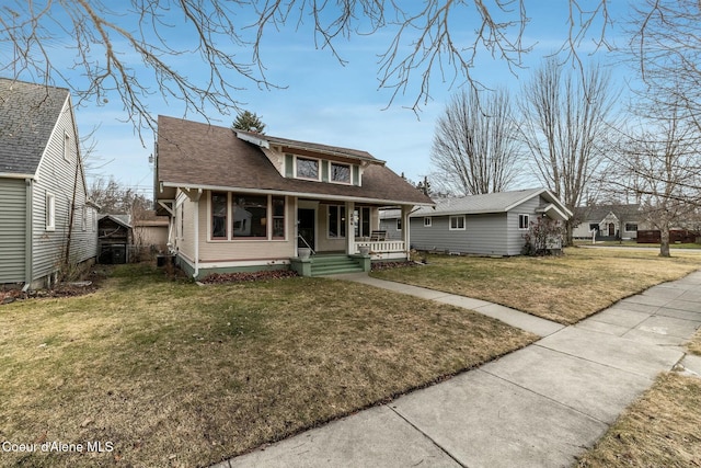 bungalow-style home featuring a porch, a shingled roof, and a front lawn