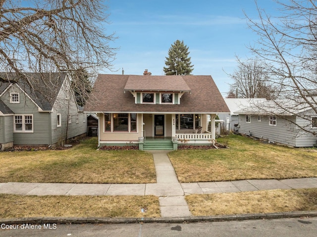 bungalow featuring a shingled roof, a chimney, a front lawn, and a porch