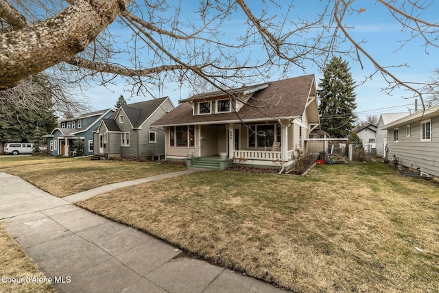 bungalow-style house with a porch, a gate, fence, and a front lawn