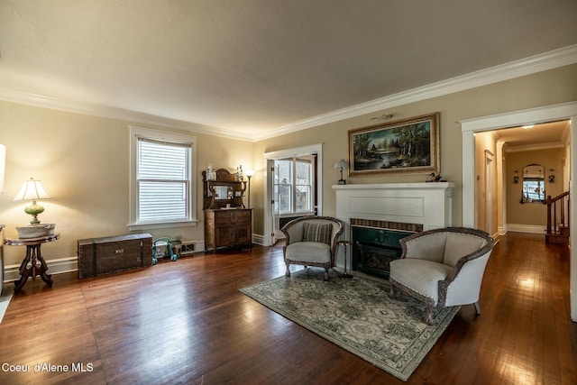 sitting room featuring crown molding, wood-type flooring, a fireplace, and baseboards