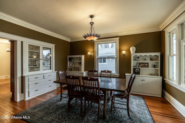 dining space featuring dark wood-style floors, a wealth of natural light, and crown molding