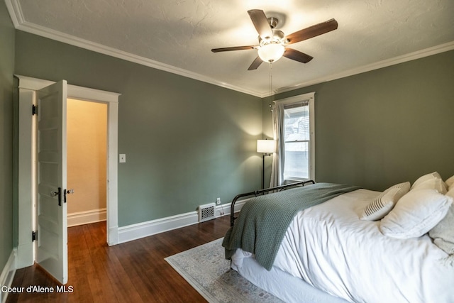 bedroom with ceiling fan, wood finished floors, visible vents, baseboards, and ornamental molding