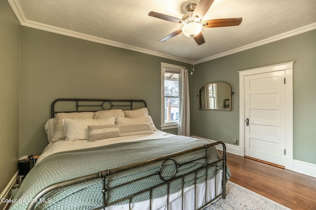 bedroom with ornamental molding, a ceiling fan, baseboards, and wood finished floors