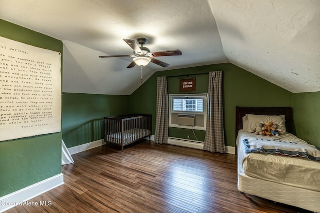 bedroom with a textured ceiling, a baseboard heating unit, baseboards, vaulted ceiling, and wood-type flooring