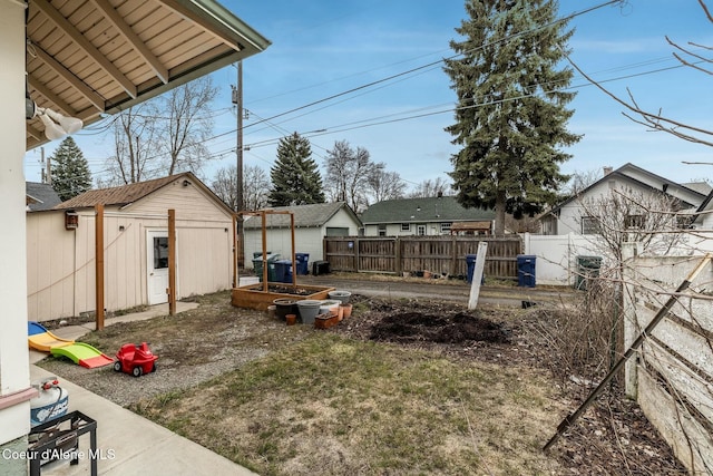 view of yard with a vegetable garden, fence, and an outdoor structure