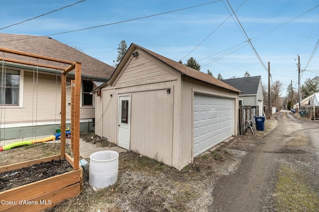 detached garage featuring a garden