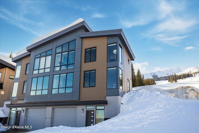 view of snow covered exterior with a garage