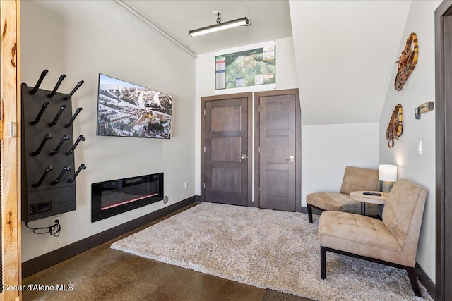 foyer entrance with a glass covered fireplace and baseboards