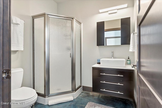 bathroom with a stall shower, baseboards, vanity, and toilet