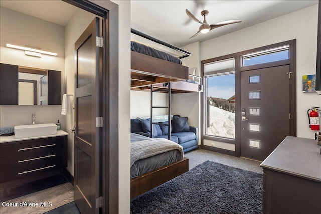 carpeted bedroom with ceiling fan, access to outside, a sink, and baseboards