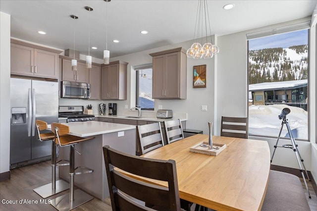 kitchen featuring recessed lighting, dark wood-style flooring, light countertops, appliances with stainless steel finishes, and a center island