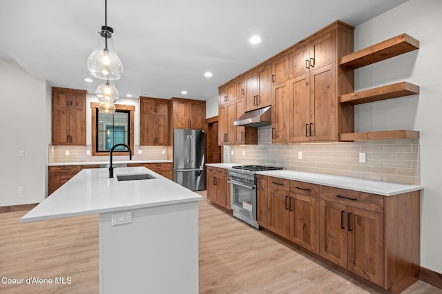 kitchen featuring under cabinet range hood, a sink, light wood-style floors, open shelves, and high end appliances