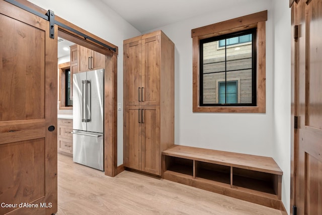 mudroom with light wood-style floors and a barn door