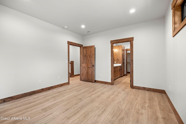 unfurnished bedroom with recessed lighting, light wood-type flooring, connected bathroom, and baseboards