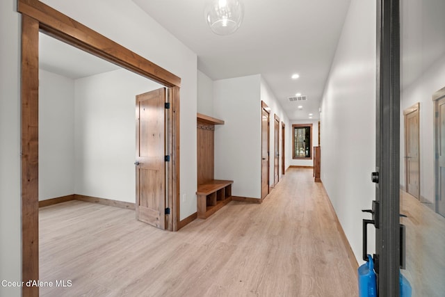 corridor with light wood finished floors, baseboards, visible vents, and recessed lighting