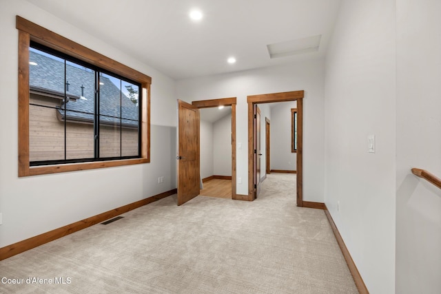 unfurnished bedroom featuring recessed lighting, light colored carpet, visible vents, attic access, and baseboards