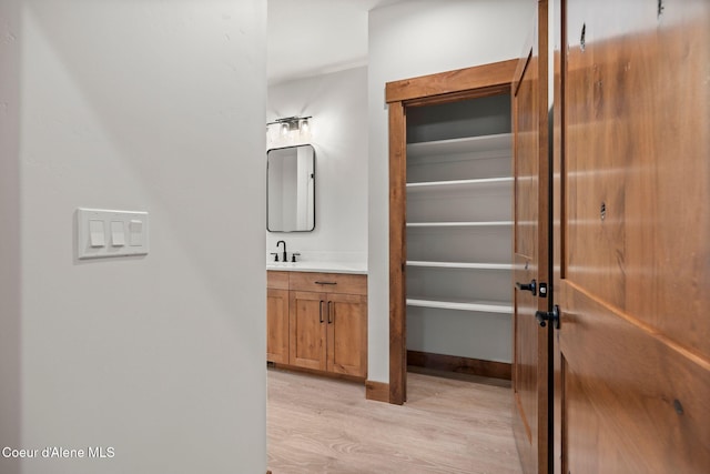 bathroom featuring baseboards, wood finished floors, and vanity