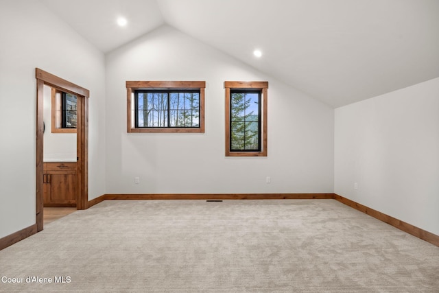 additional living space with lofted ceiling, baseboards, and light colored carpet